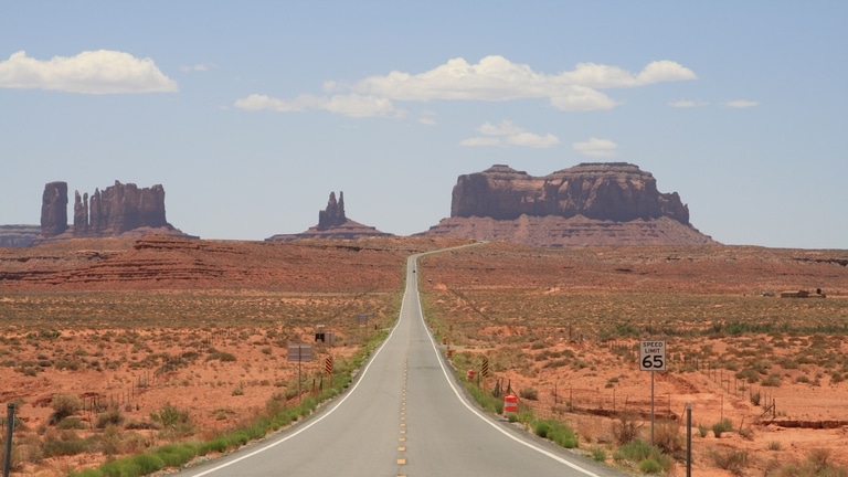 aflopende weg met in de verte de butes van monument valley.